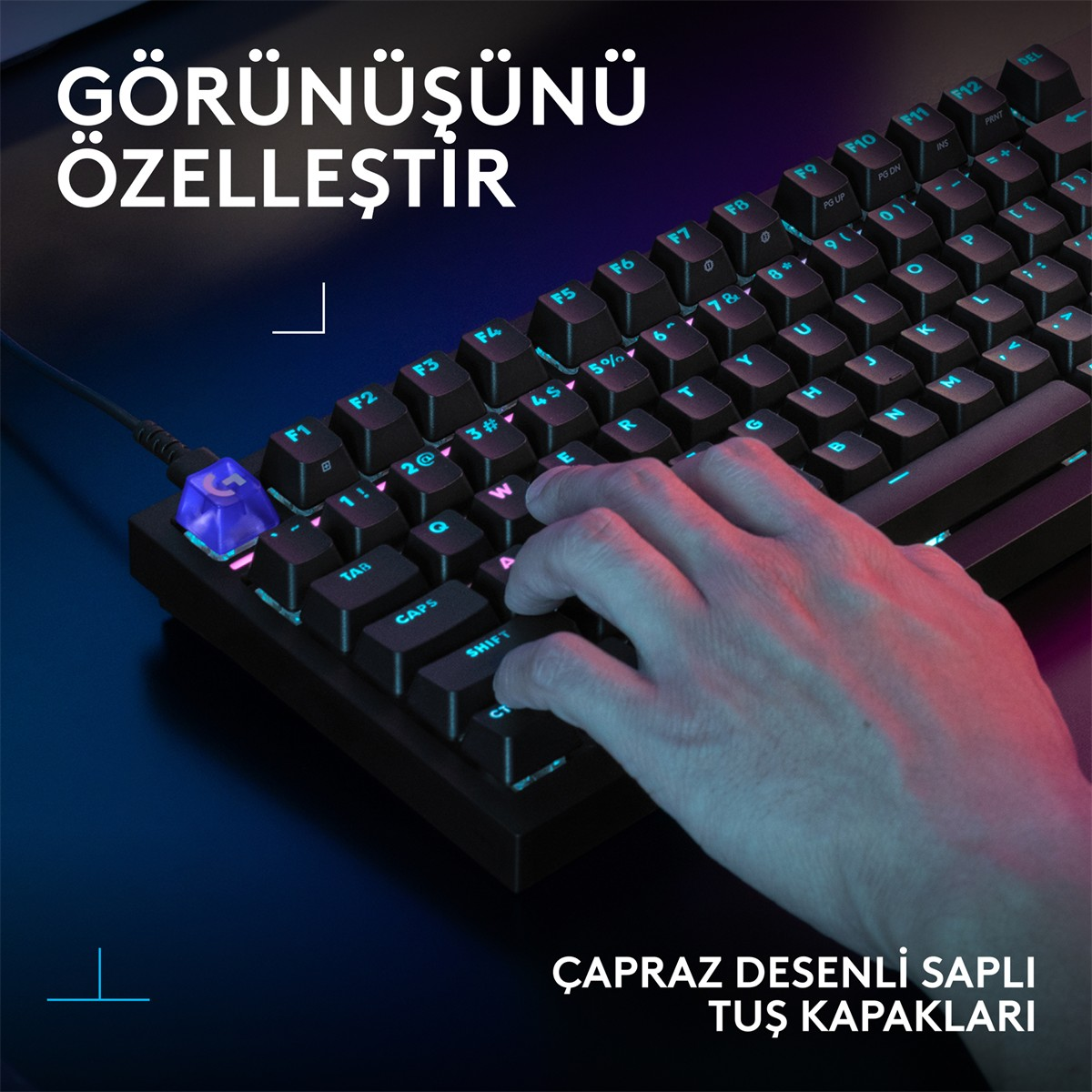 Mavi aydınlatmalı klavyede bir el. Odak noktası klavyedir.