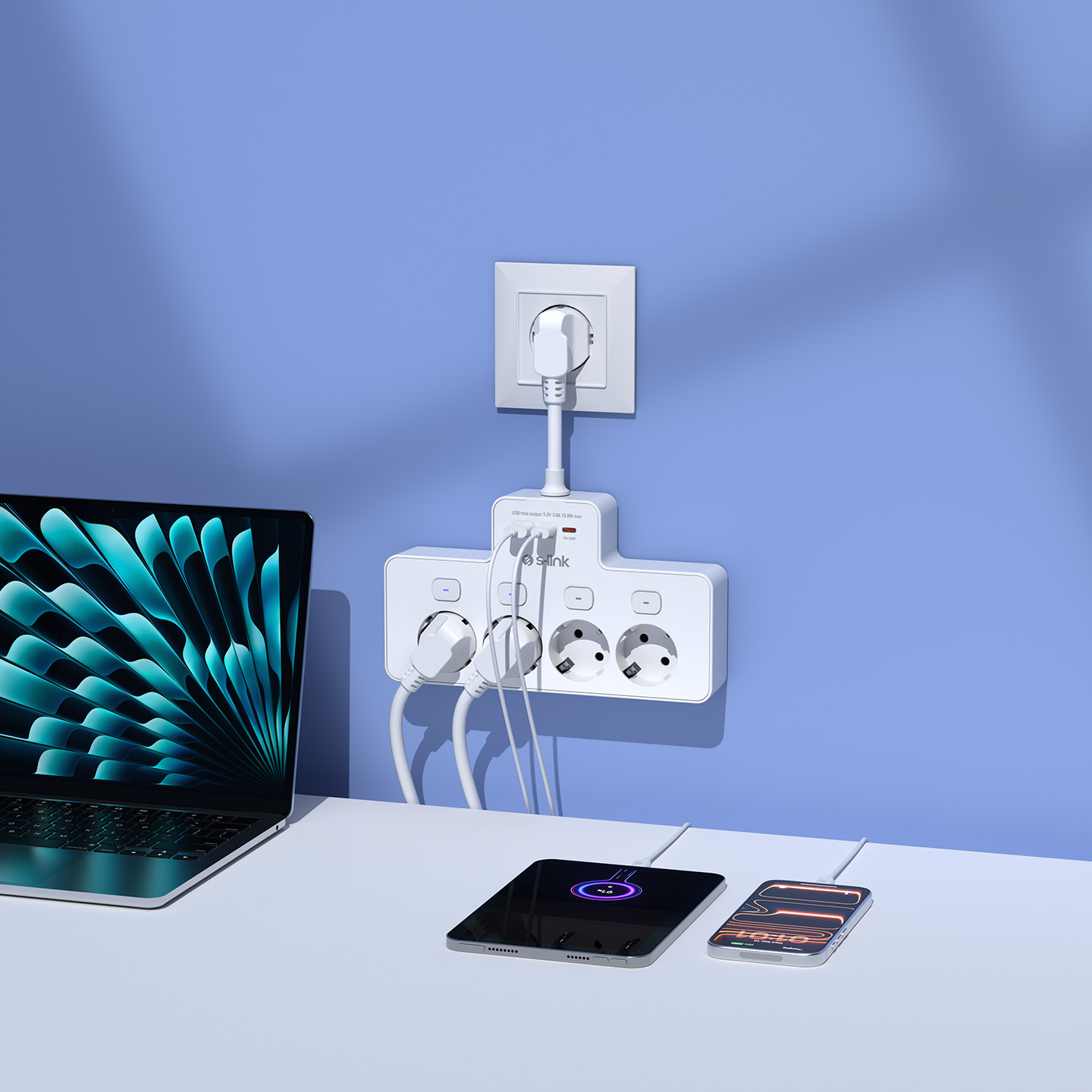 Mavi duvarda beyaz bir uzatma kablosu aracılığıyla şarj olan bir dizüstü bilgisayar, tablet ve akıllı telefon.
