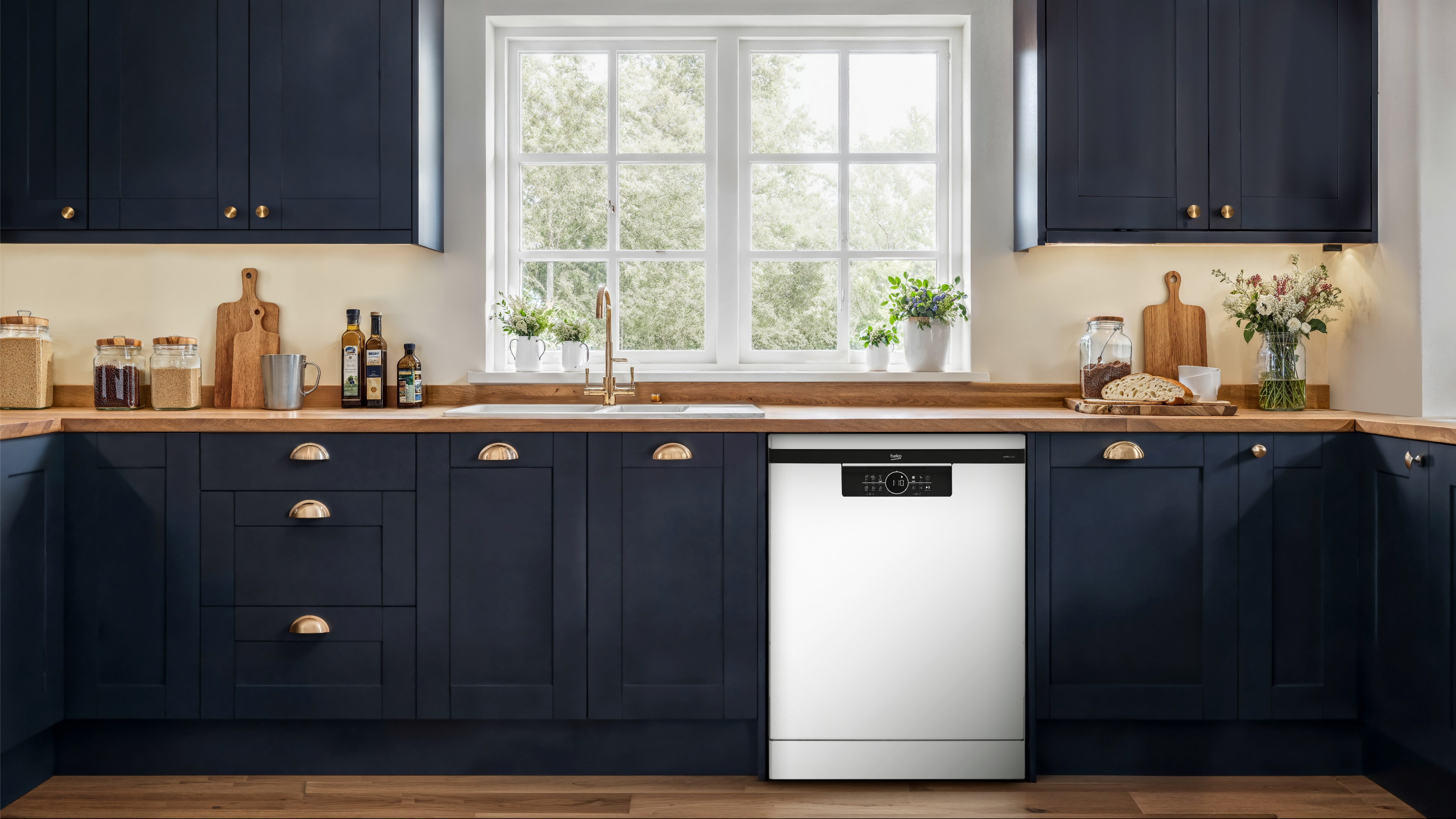 Cocina moderna con gabinetes oscuros, encimera de madera y lavavajillas blanco.