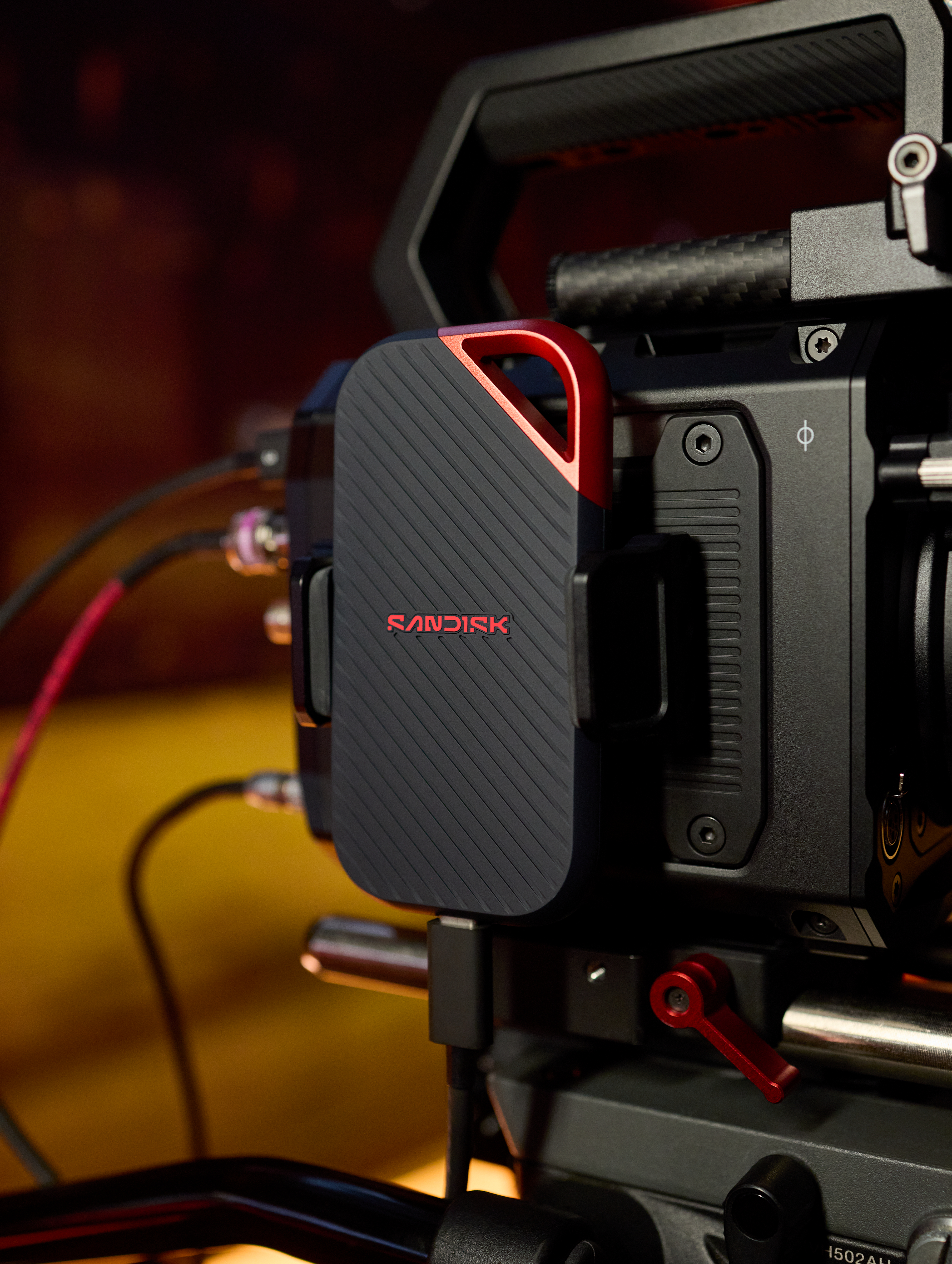 Ein schwarzes SanDisk-Laufwerk ist an einer Filmkamera befestigt, mit roten Akzenten.