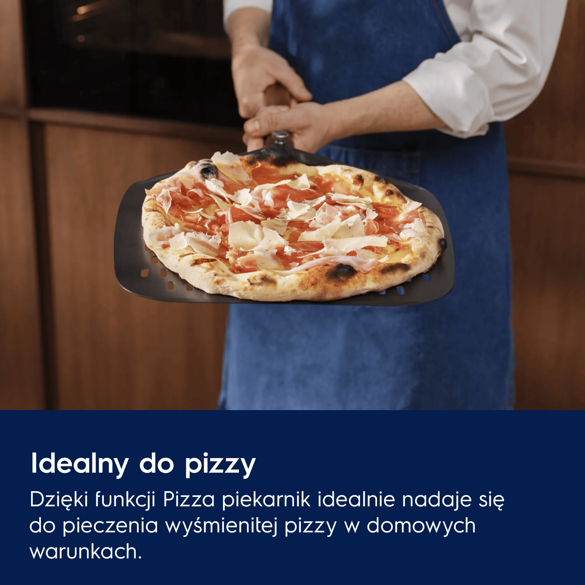 Mężczyzna w fartuchu trzyma świeżo upieczoną pizzę na łopacie.