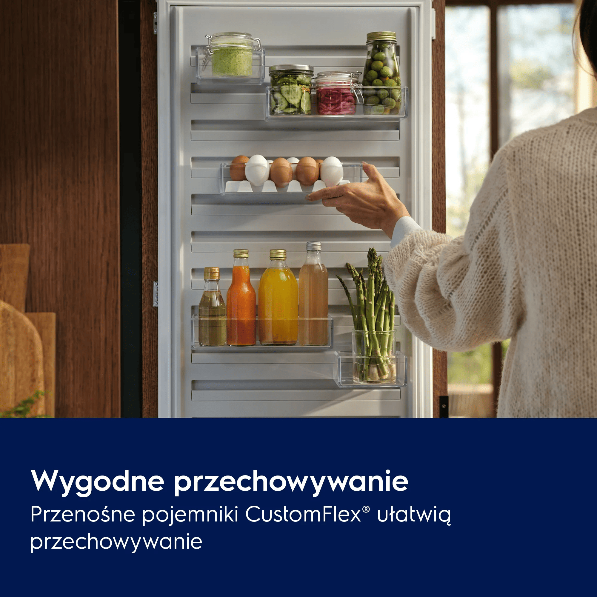 Ręka sięga po jajka w lodówce z słoikami i butelkami.