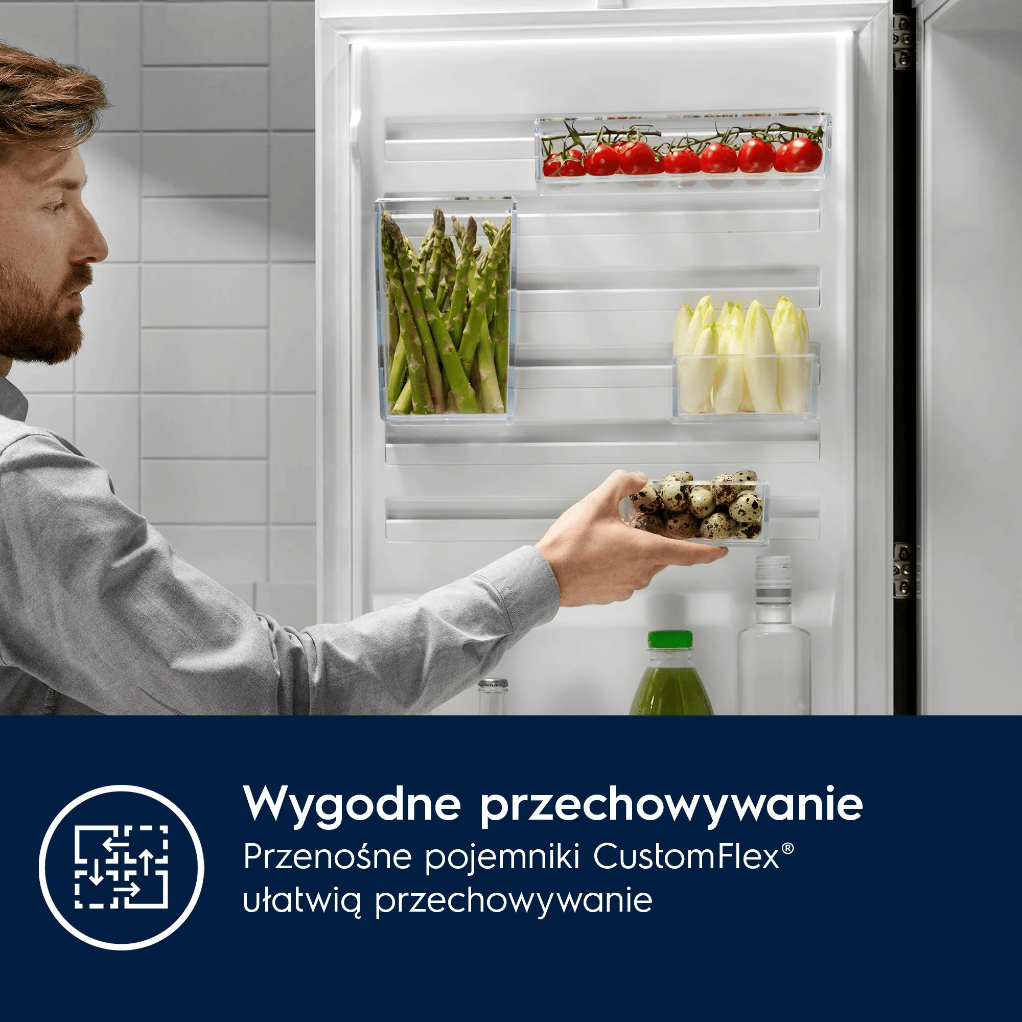 Mężczyzna otwiera lodówkę ze szparagami, pomidorami, cykorią, jajkami, sokiem.