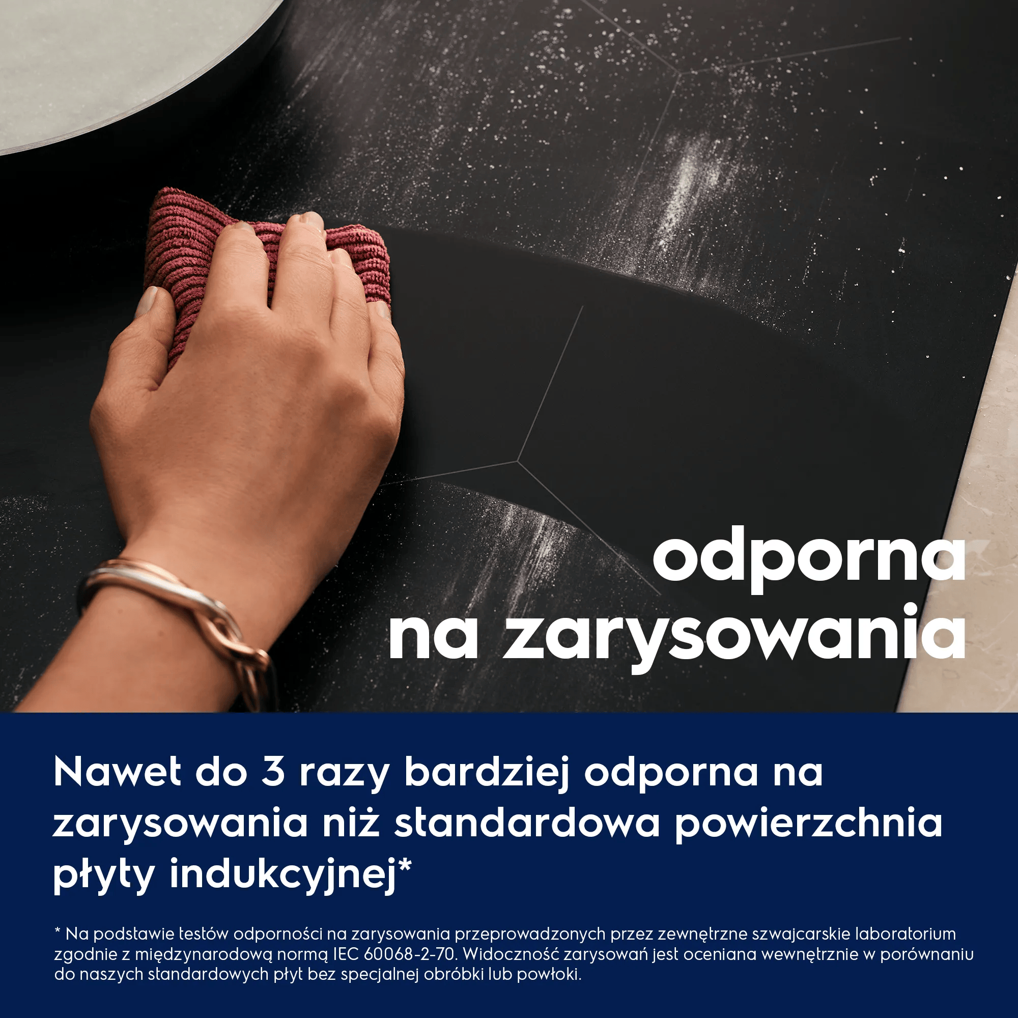 Ręka z czerwonym ręcznikiem wyciera czarną powierzchnię.