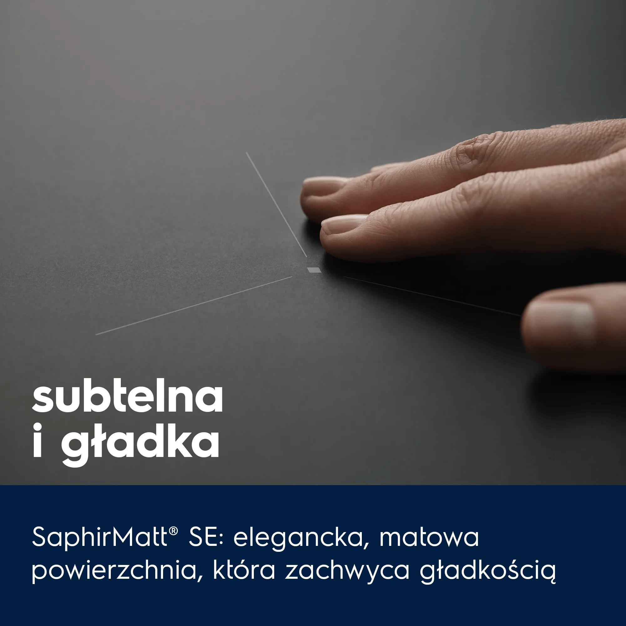 Dłoń dotyka matowej, ciemnej powierzchni z delikatnymi liniami.