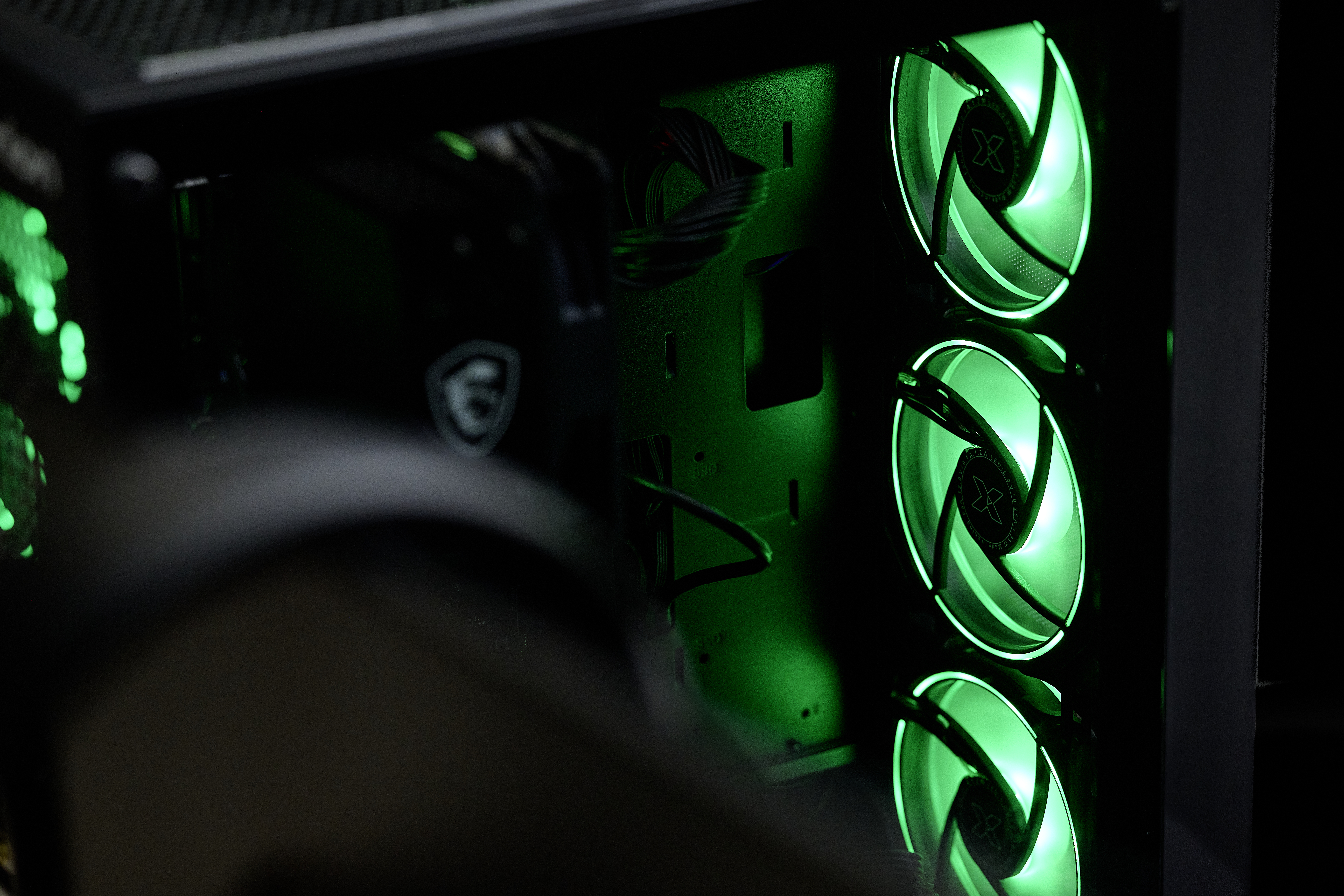 Ein PC-Gehäuse mit grünen LED-Lüftern und Kabeln.