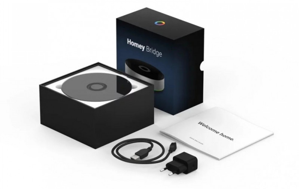 Homey Bridge készlet dobozzal, kézikönyvvel, USB-kábellel és hálózati adapterrel.