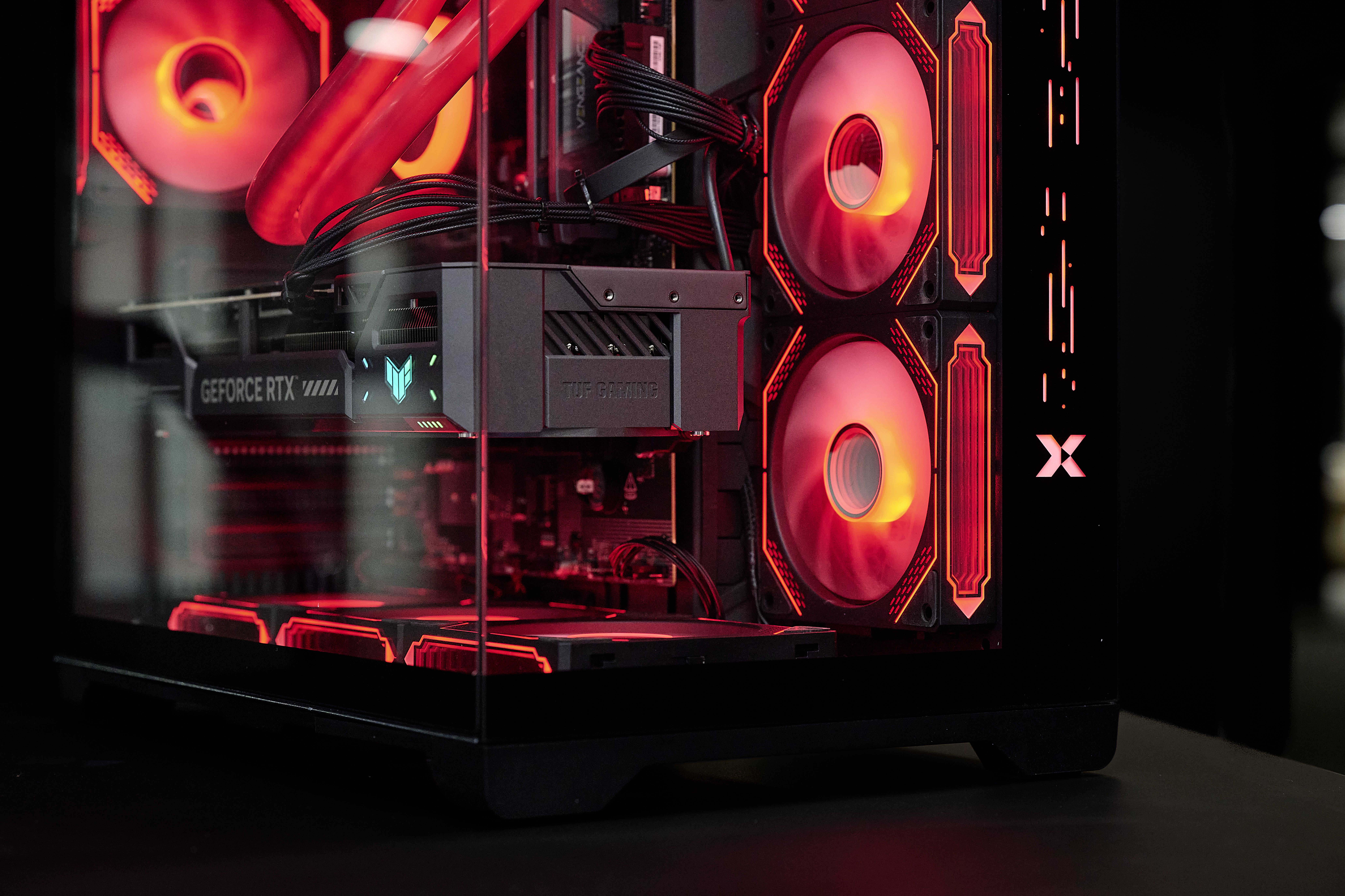 Ein schwarzer Computerturm mit roter LED-Beleuchtung an Lüftern und Komponenten.