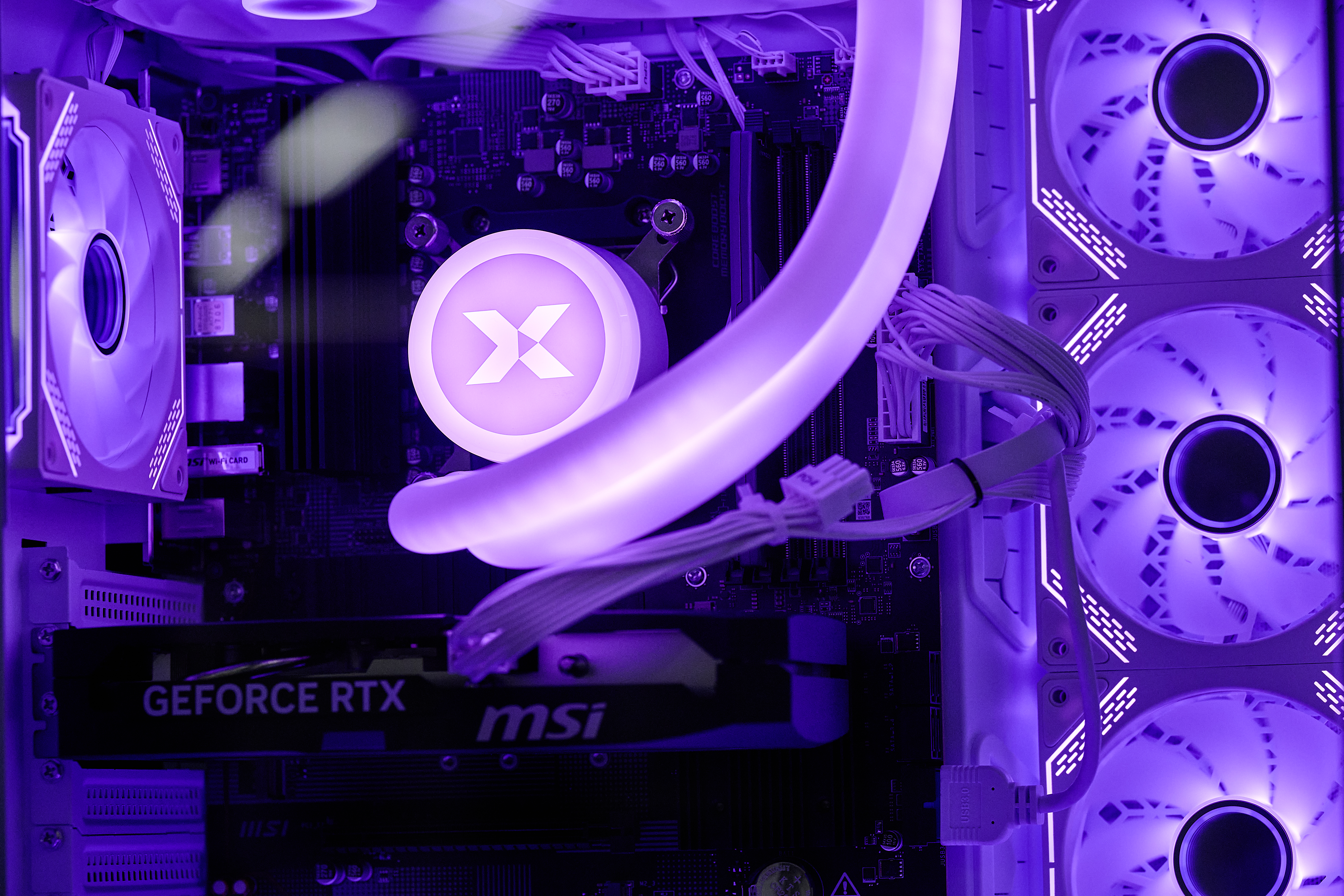 Ein PC-Innenraum mit lila Lüftern, einer Grafikkarte und beleuchteten Komponenten.