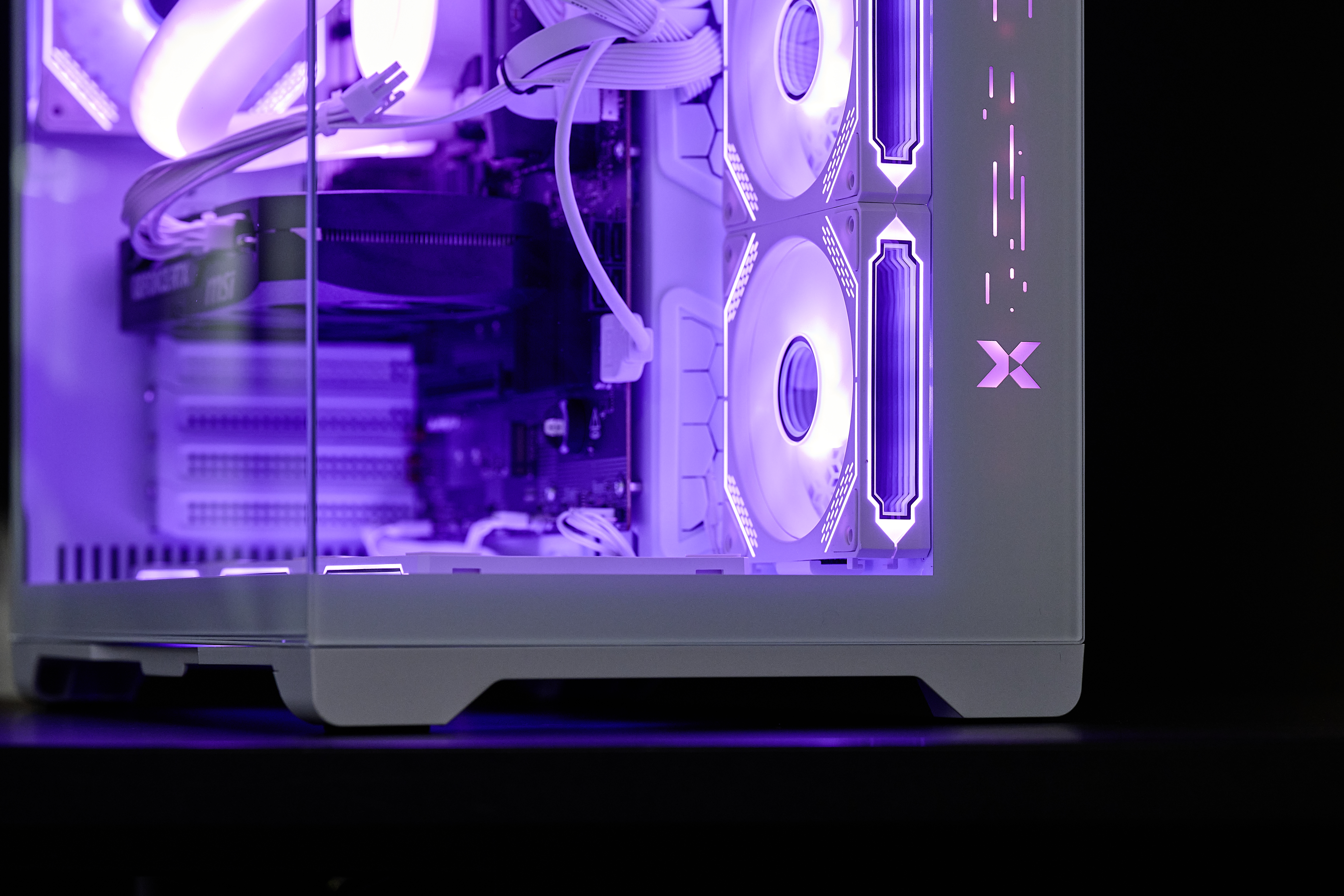 Ein weier Gaming-PC mit lila RGB-Beleuchtung und Glasfront.