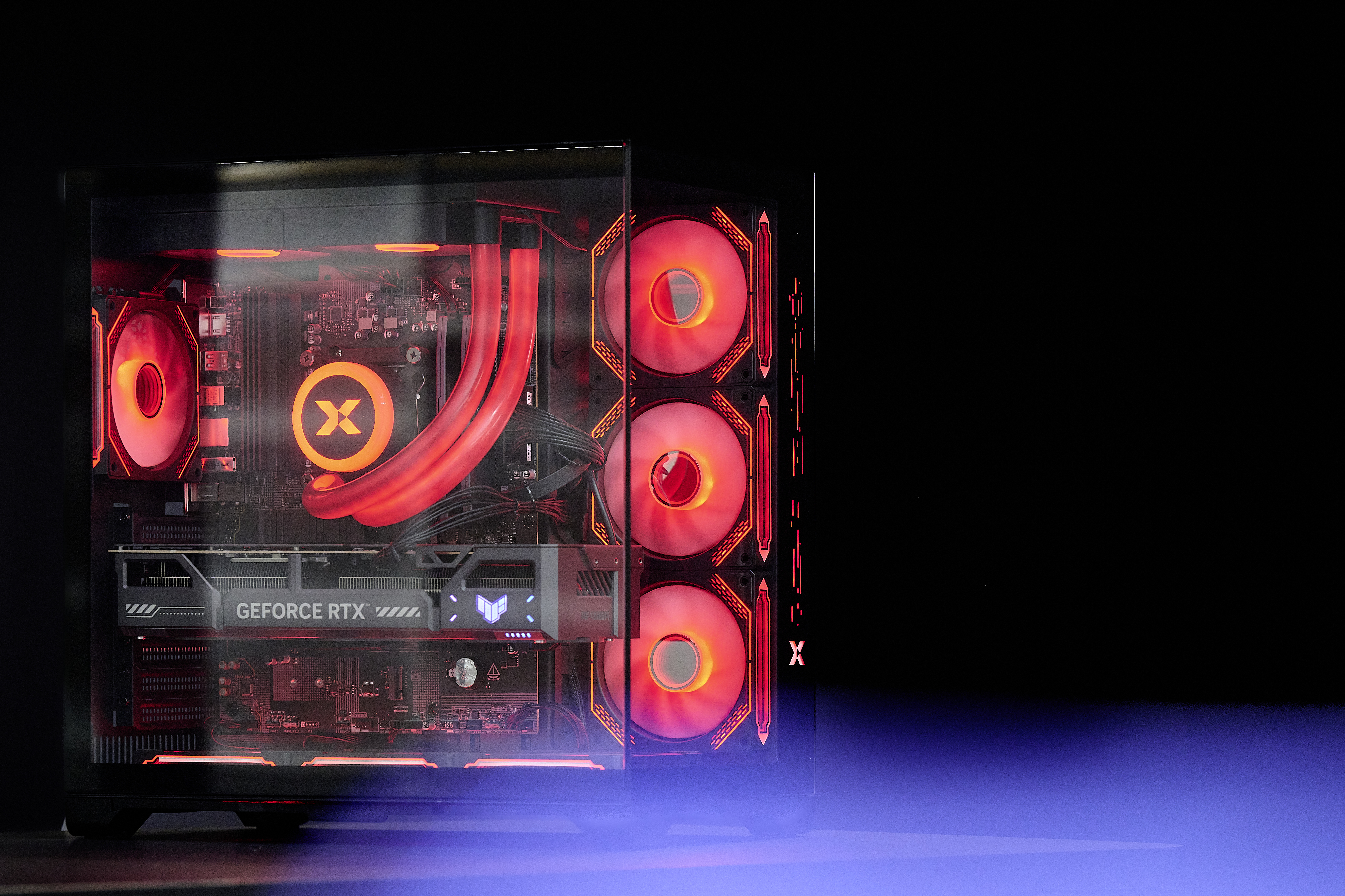 Ein rot beleuchteter Gaming-PC mit Custom-Wasserkühlung und RGB-Lüftern vor schwarzem Hintergrund.