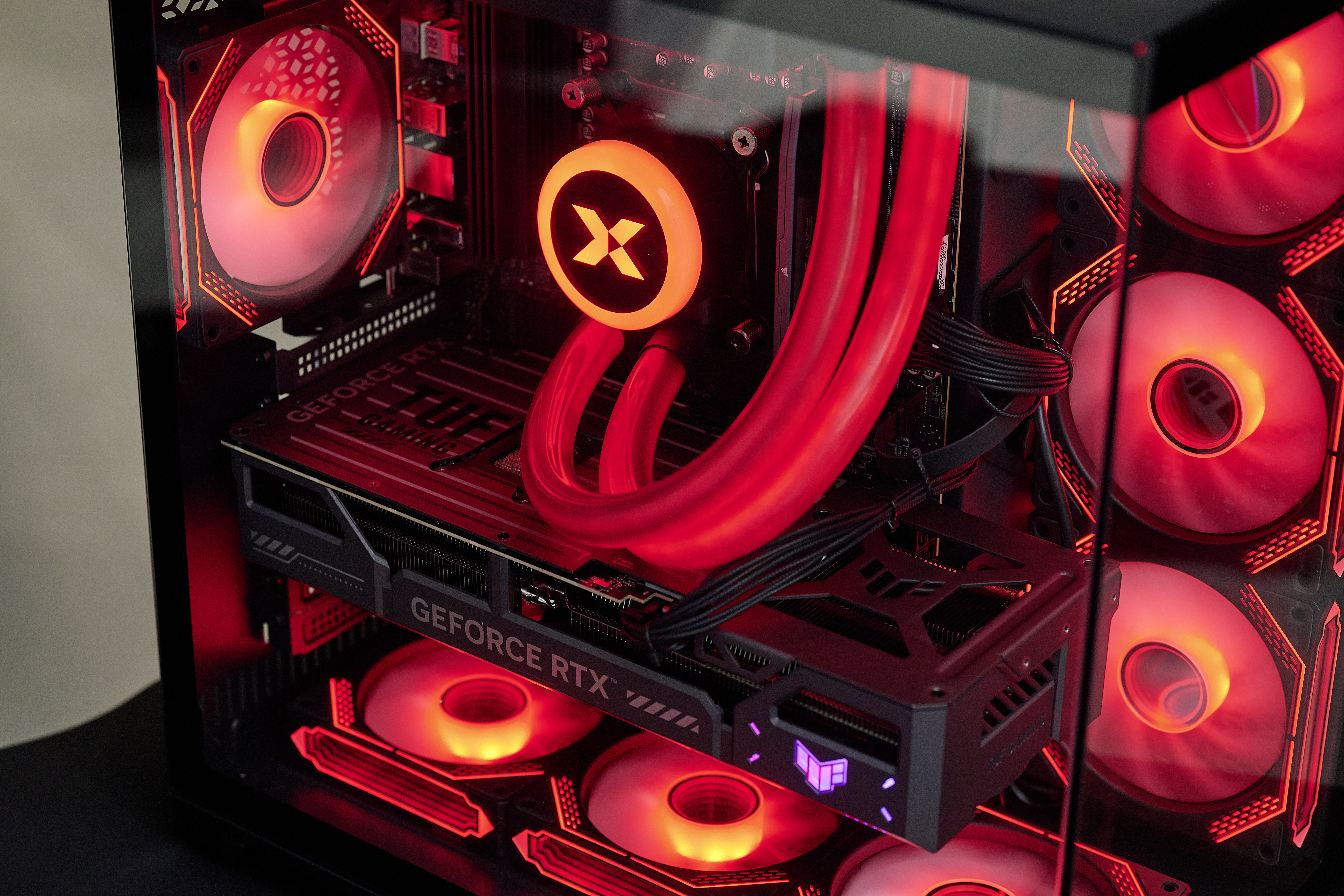 Ein Gaming-PC mit roter RGB-Beleuchtung, Wasserkühlung und einer RTX-Grafikkarte.