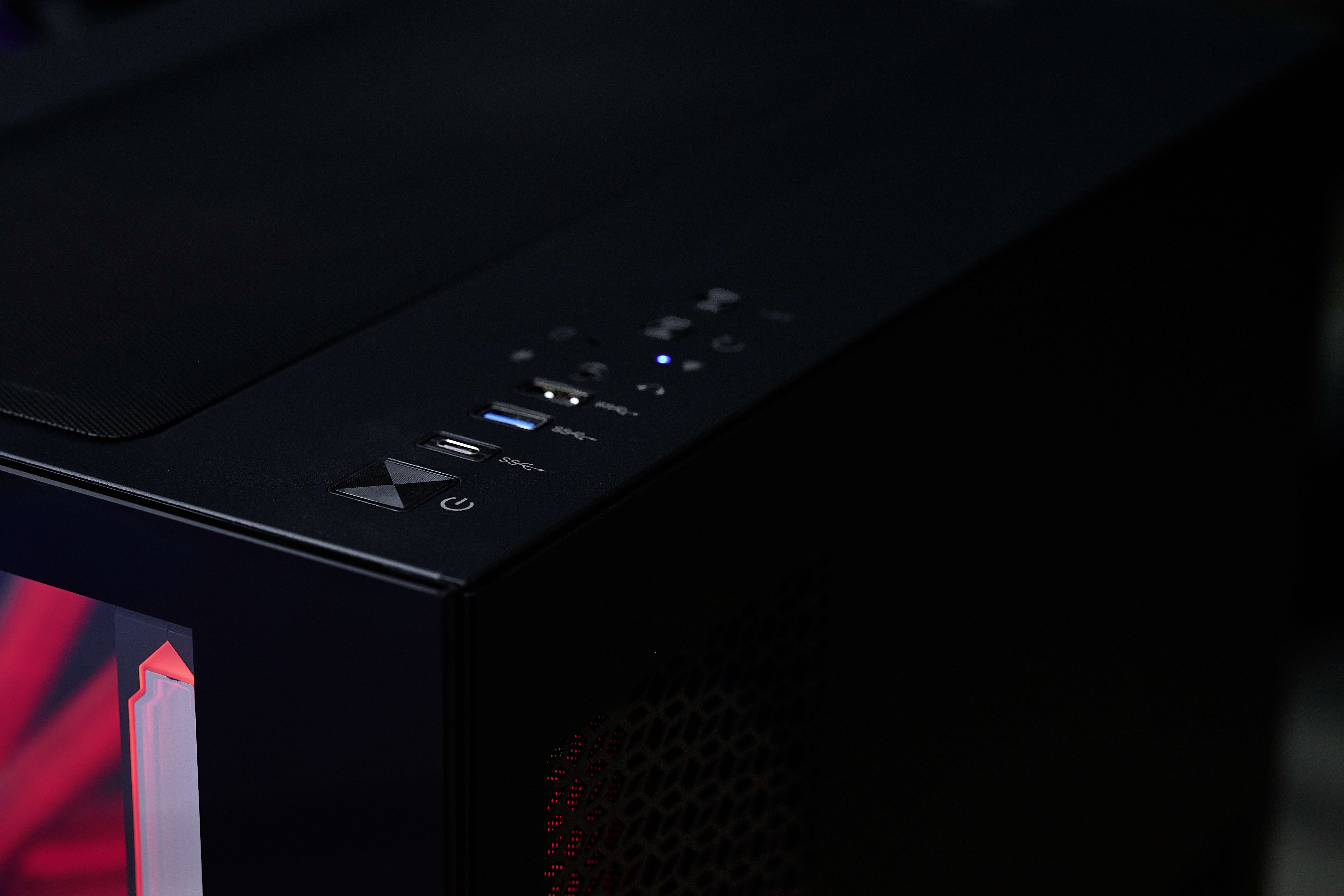 Schwarzes Computergehäuse mit USB-Ports, Ein/Aus-Taste und roter Innenbeleuchtung.