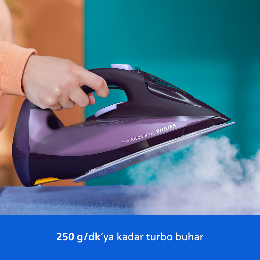 Bir el, mavi kumaşın üzerinde buhar yayan mor bir buharlı ütü tutuyor.