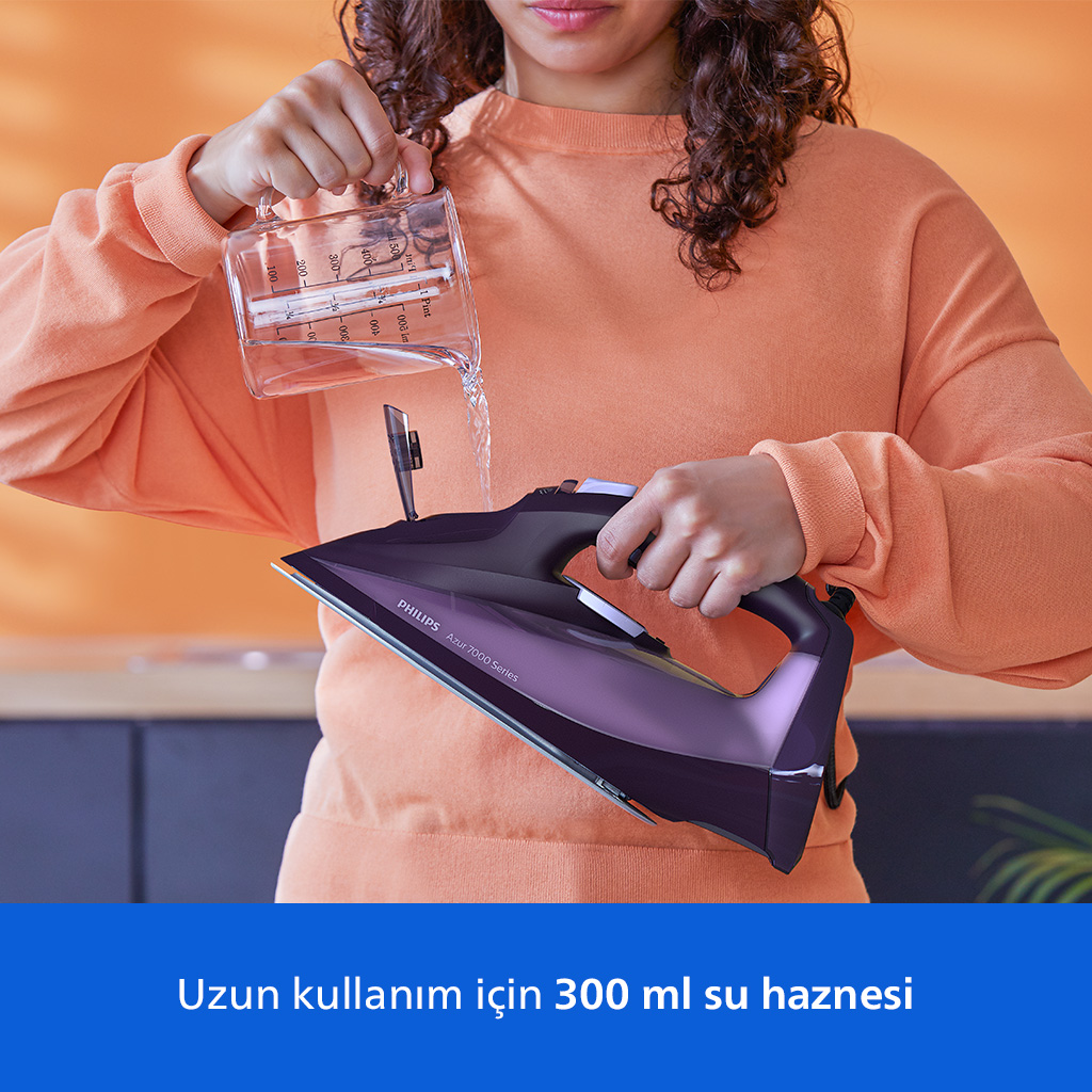Bir kişi ölçüm kabından ütüye su döküyor.