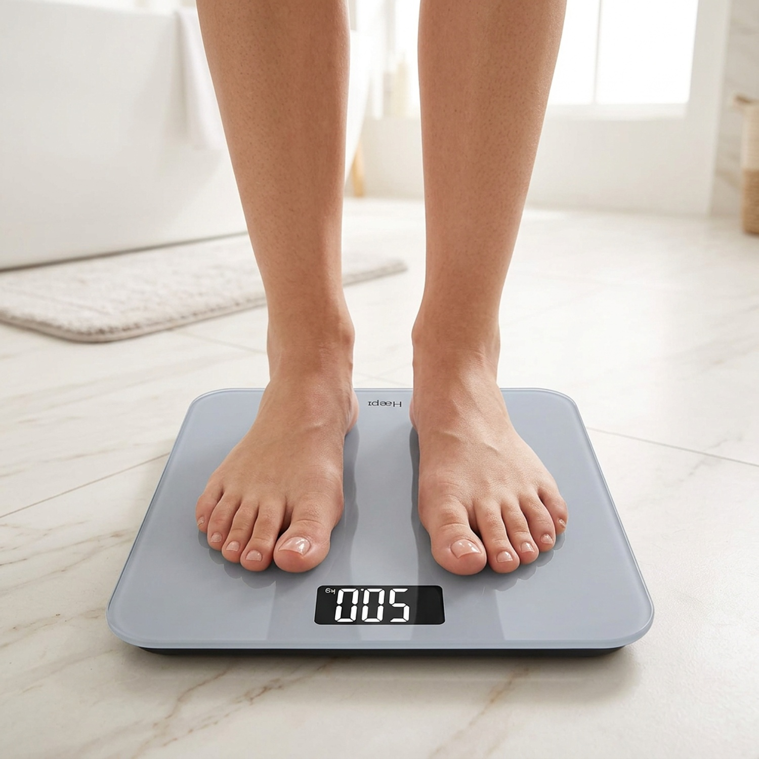 Feet on a gray digital bathroom scale in a bathroom setting.