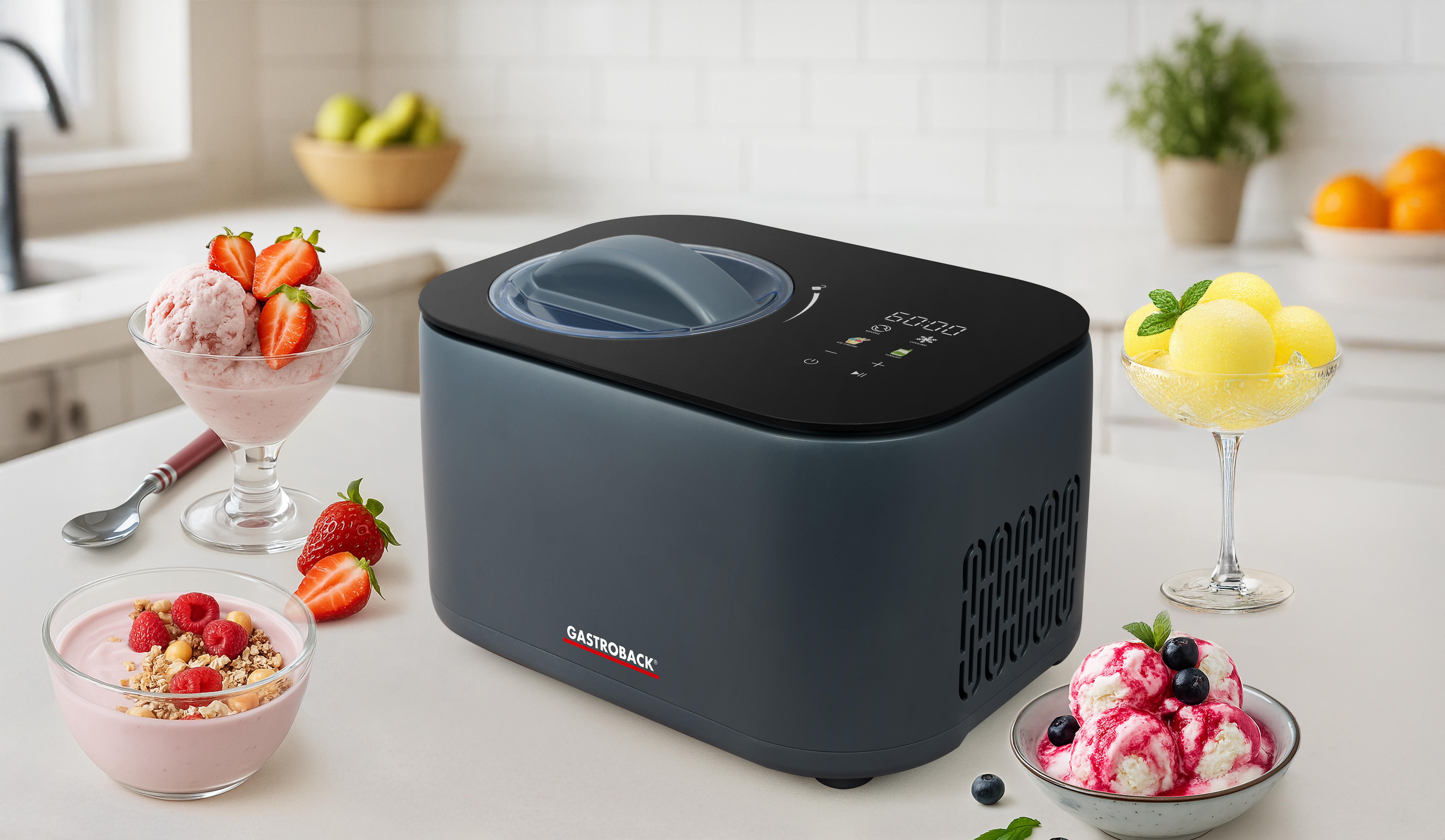 Eine dunkle Eismaschine steht auf einer Arbeitsplatte mit Eiscreme und Obst.
