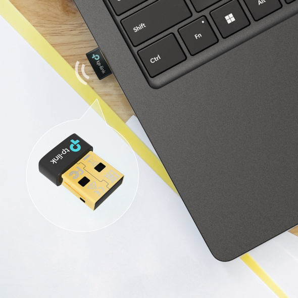 Egy kis TP-Link logós USB adapter csatlakozik egy laptophoz.
