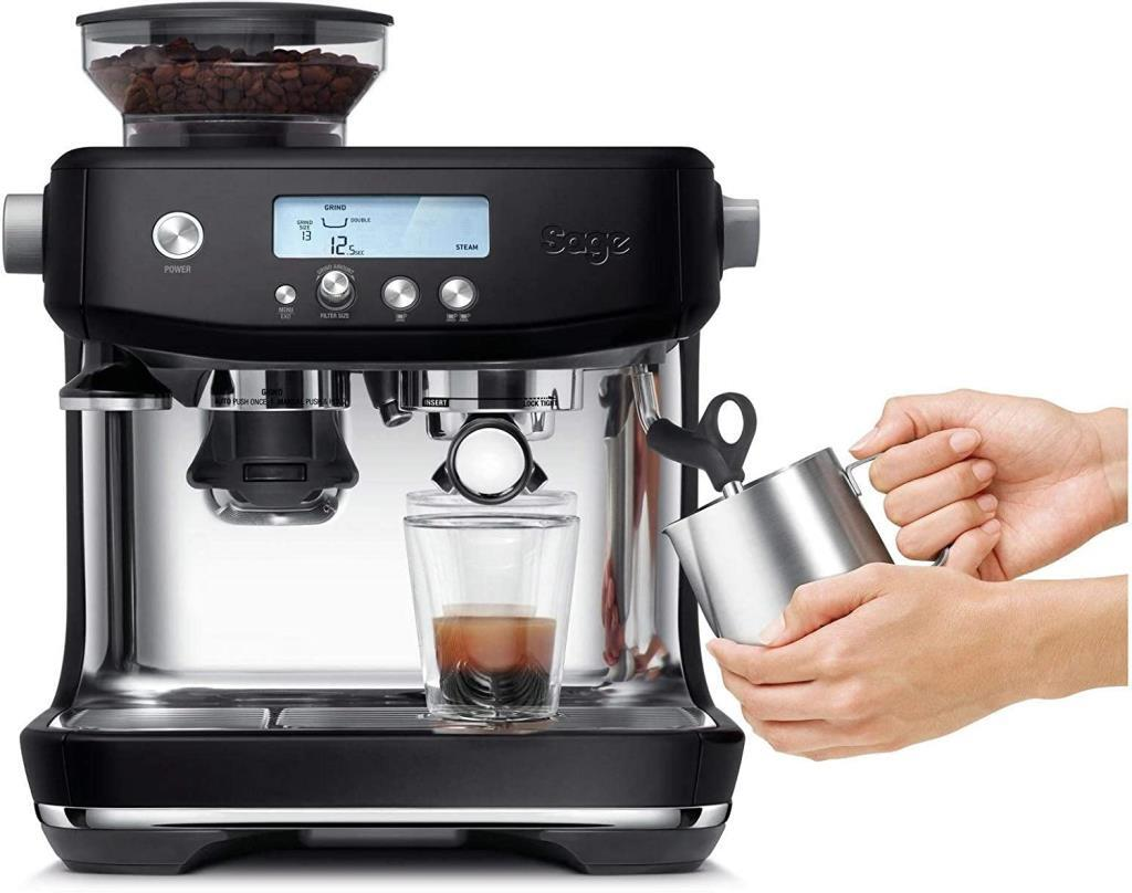 Una máquina de espresso negra con portafiltro, jarra de leche y tolva de granos.