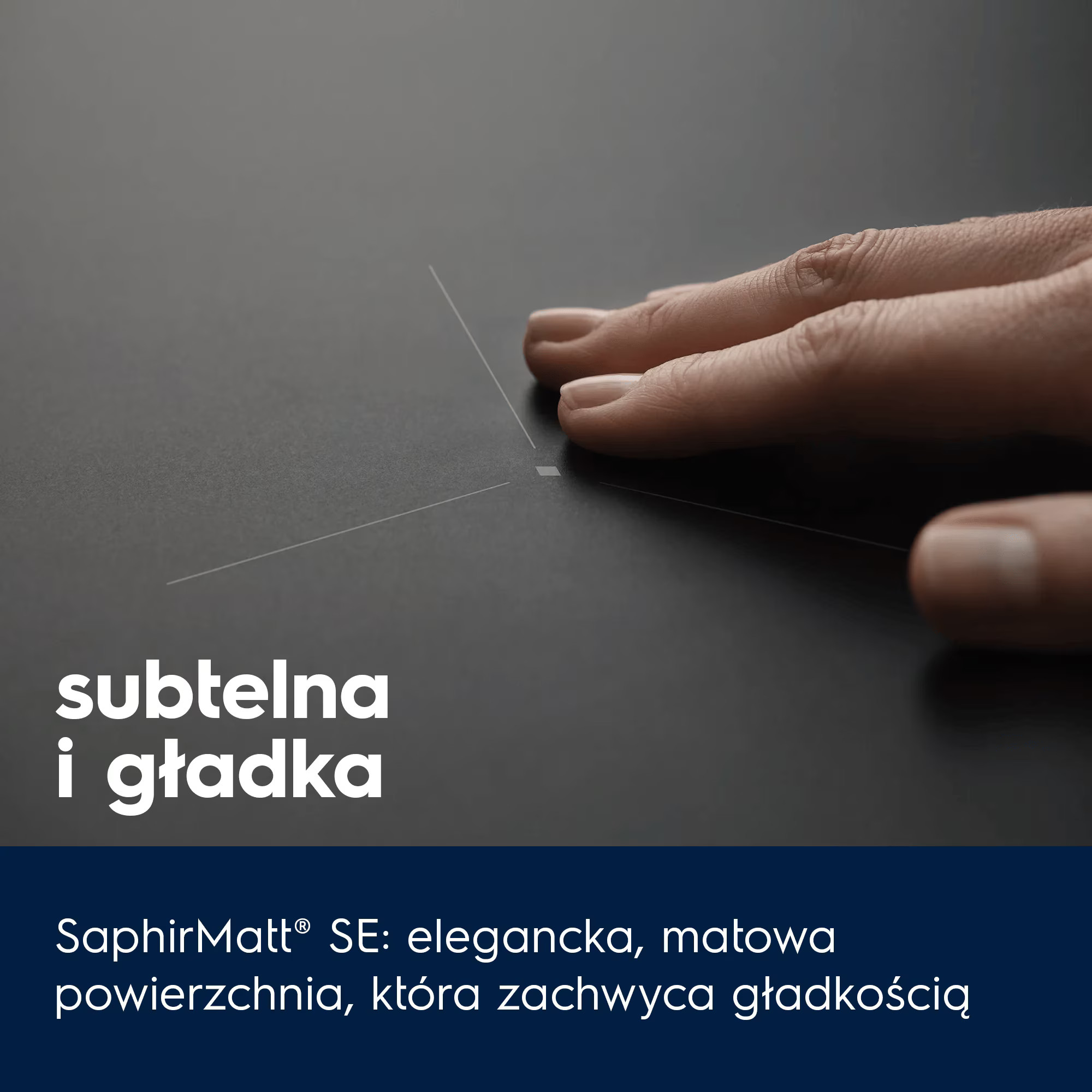 Dłoń dotyka gładkiej, ciemnej powierzchni z delikatnymi liniami.