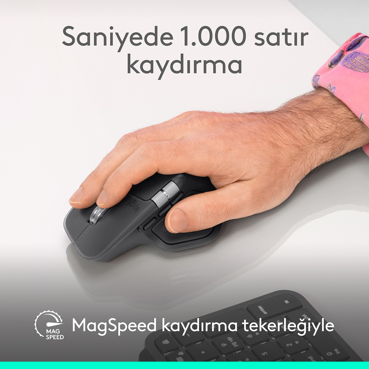 Bir el, klavyenin önünde gri bir Logitech fare kullanıyor.