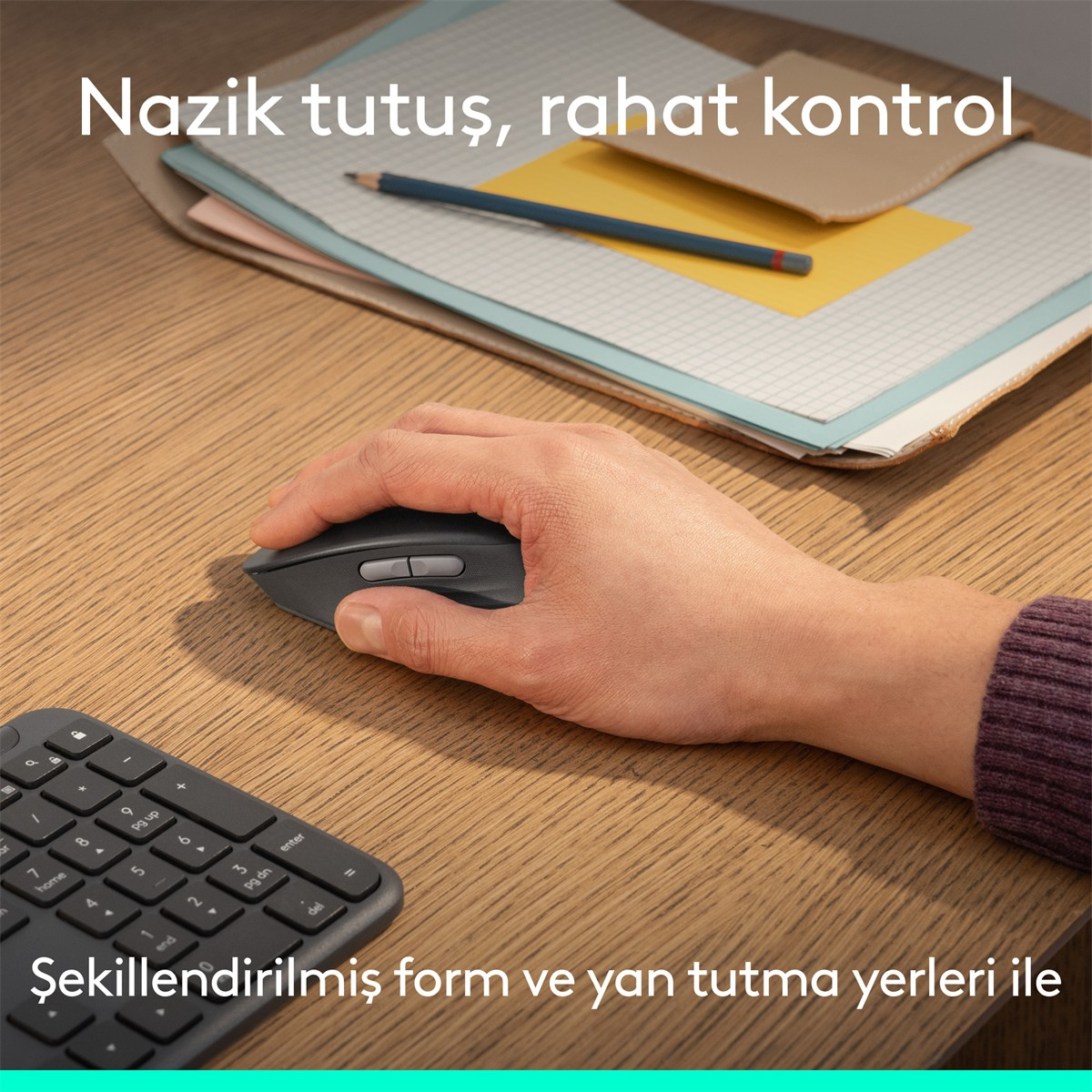 Bir el, klavye ve not defterlerinin yanında ahşap bir masada siyah fare kullanıyor.