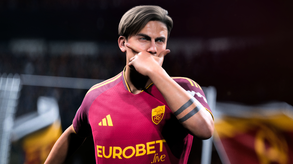 Ein Fußballspieler in einem roten Trikot mit gelben Streifen gestikuliert vor einem dunklen Hintergrund.