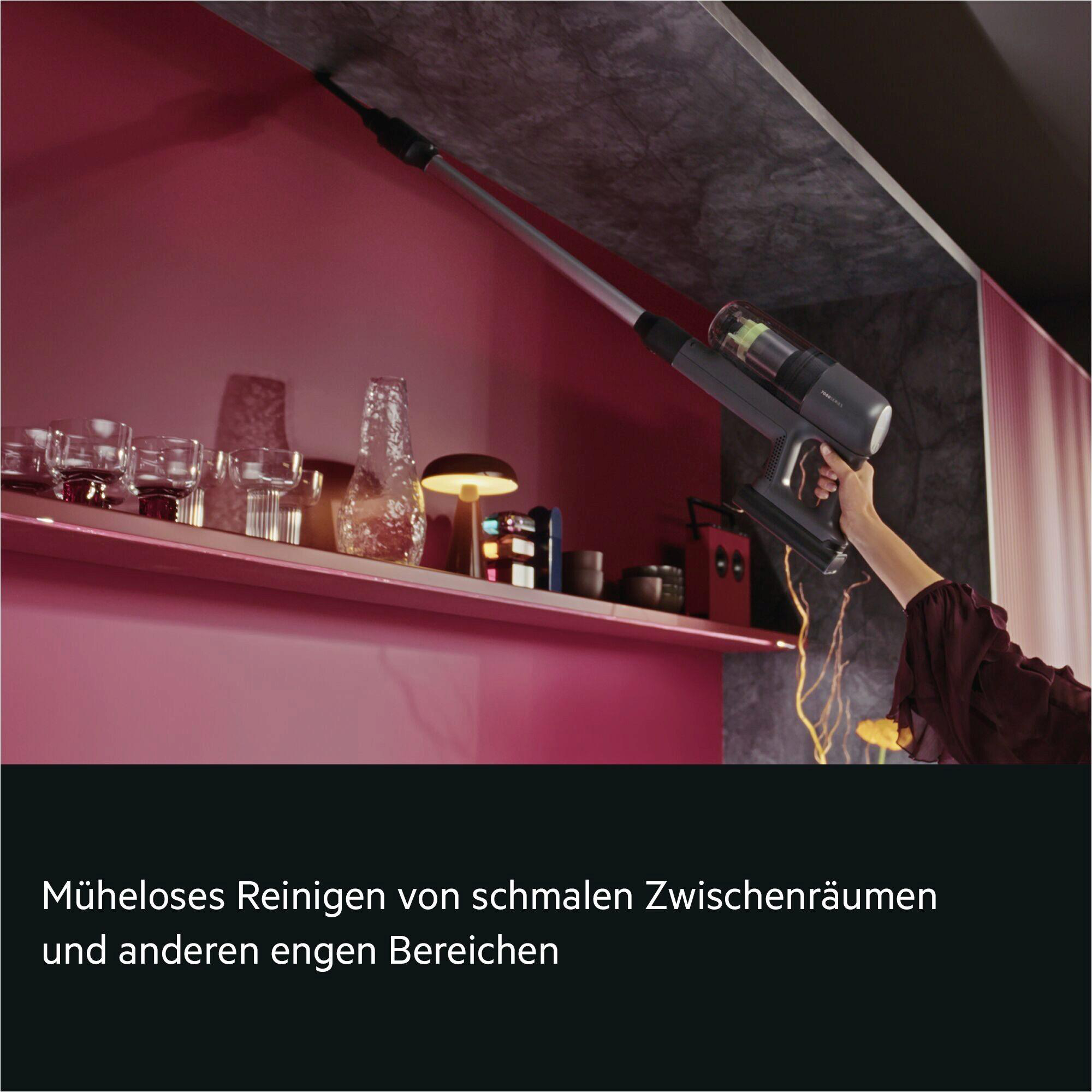 Ein Handstaubsauger reinigt eine Decke mit schmalem Spalt.