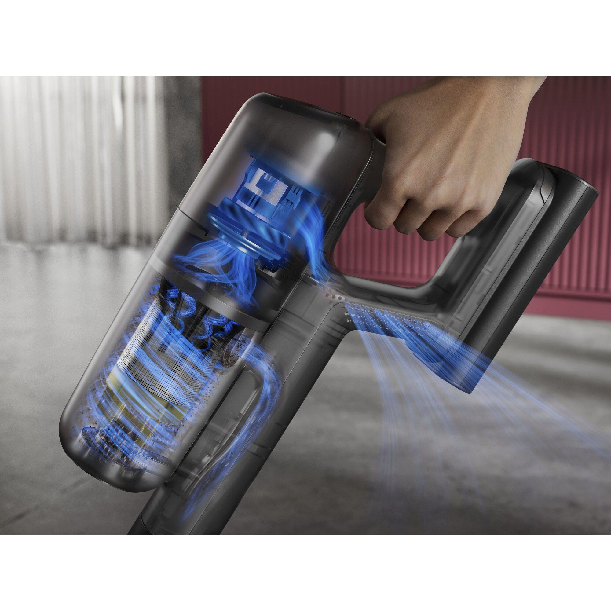 Hand hält transparenten Staubsauger mit blauem Luftstrom, der den Filter zeigt.