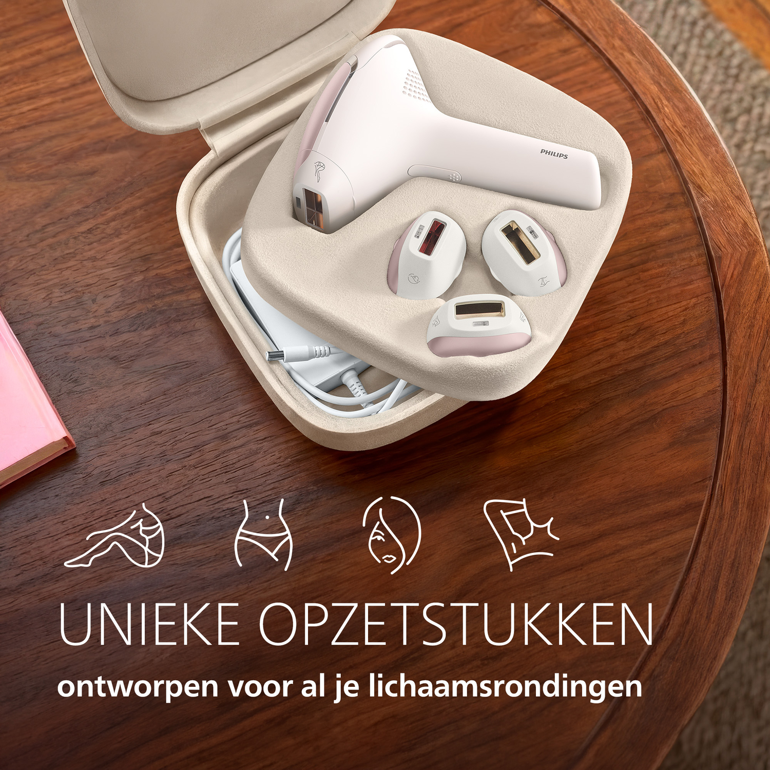 Un épilateur IPL blanc avec accessoires dans un étui beige sur une table en bois.