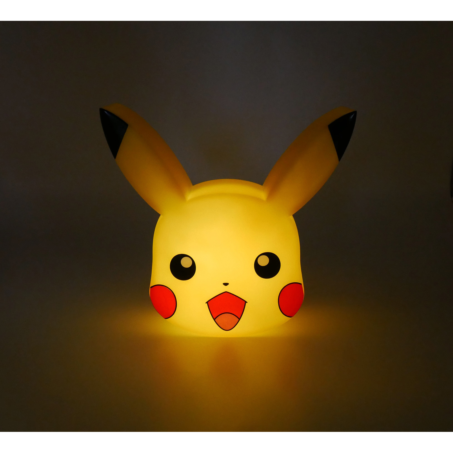 Een gloeiende Pikachu lamp met geel licht en zwarte oorpunten.