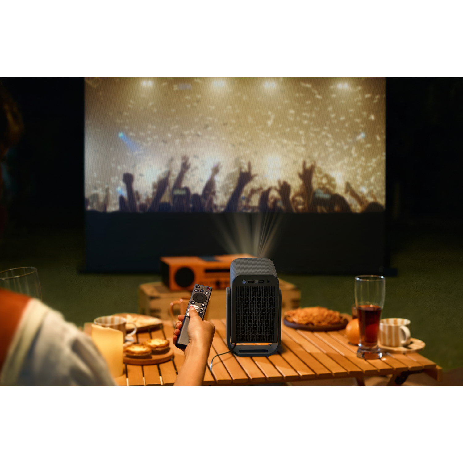 Un projecteur portable est sur une table en bois, avec des boissons et des collations.