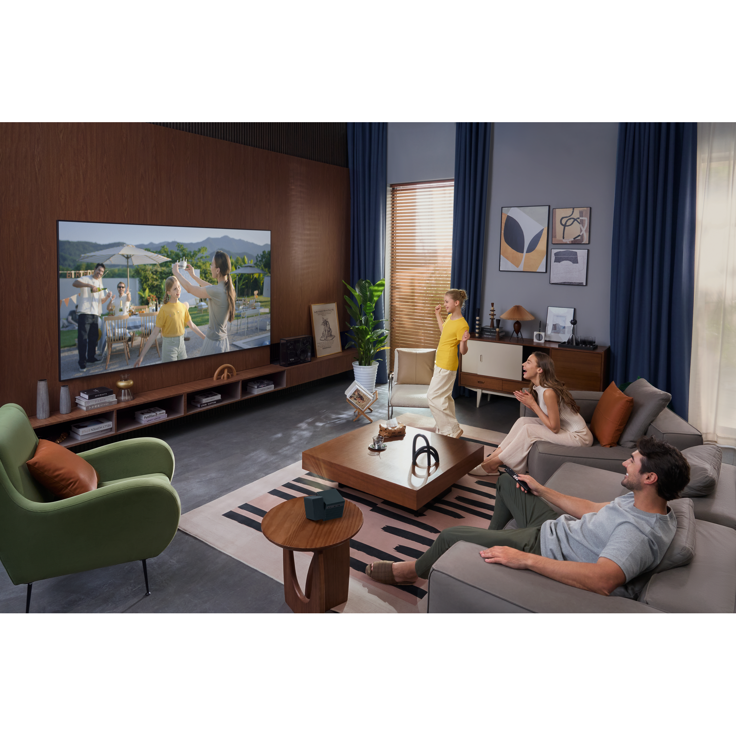Famille regardant la TV dans le salon. Homme sur canapé, femme et enfant dansent.