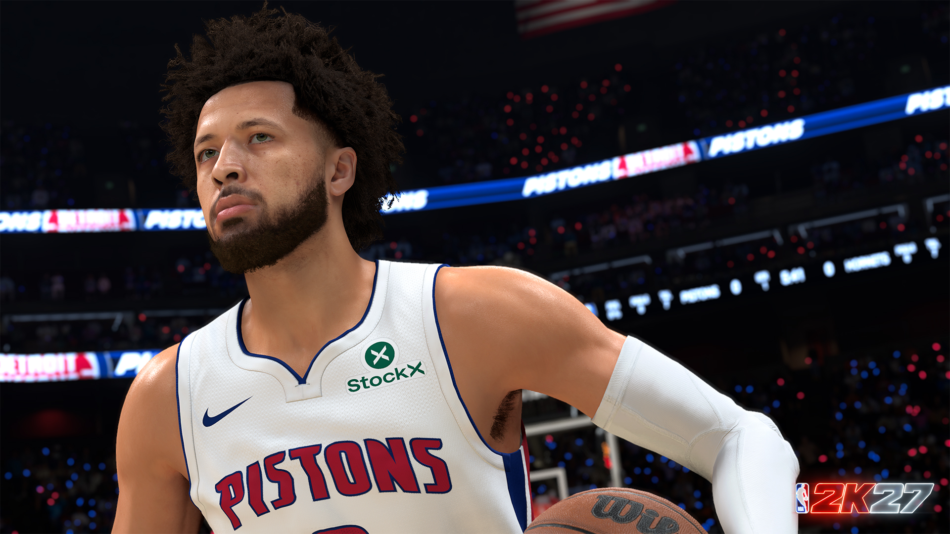 Jugador de baloncesto con camiseta blanca de los Pistons y logo verde StockX, mirando hacia arriba. Público de la arena al fondo.