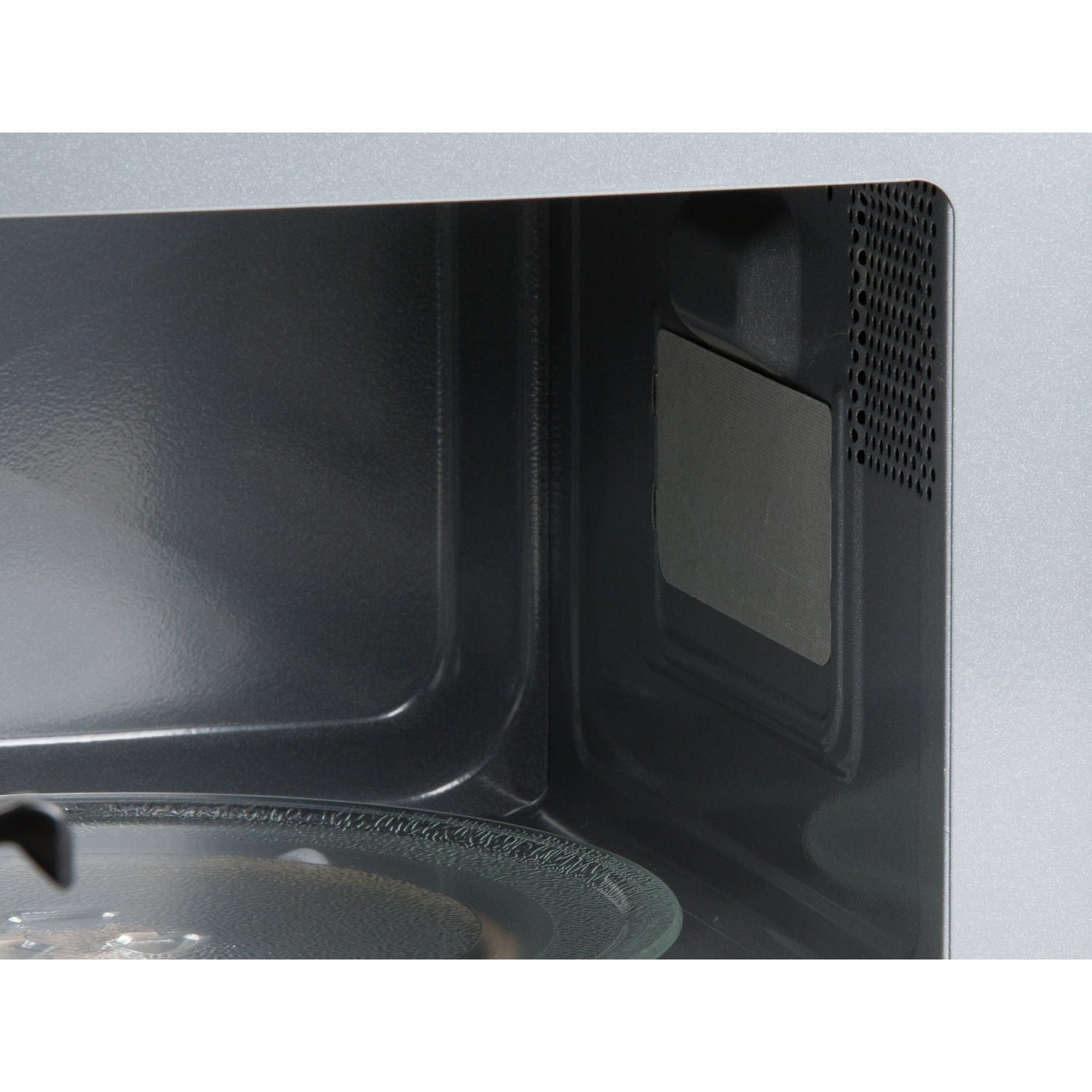 Vue intérieure d'un micro-ondes, montrant un plateau tournant en verre et une grille.