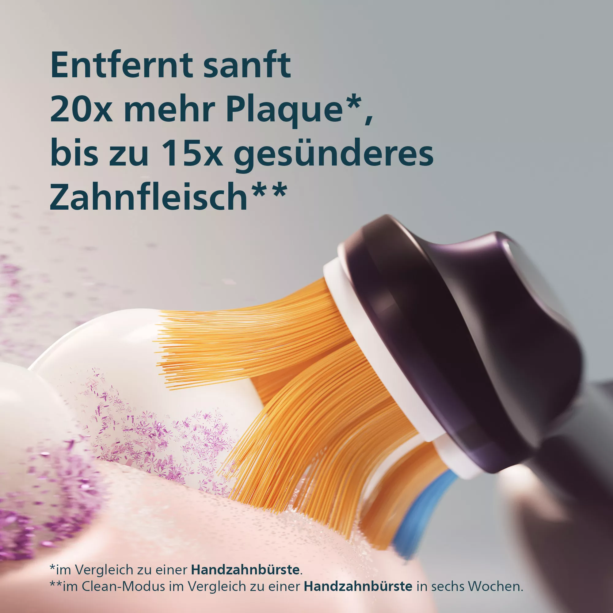 Elektrische Zahnbürstenköpfe mit orangefarbenen Borsten auf hellrosa Oberfläche.