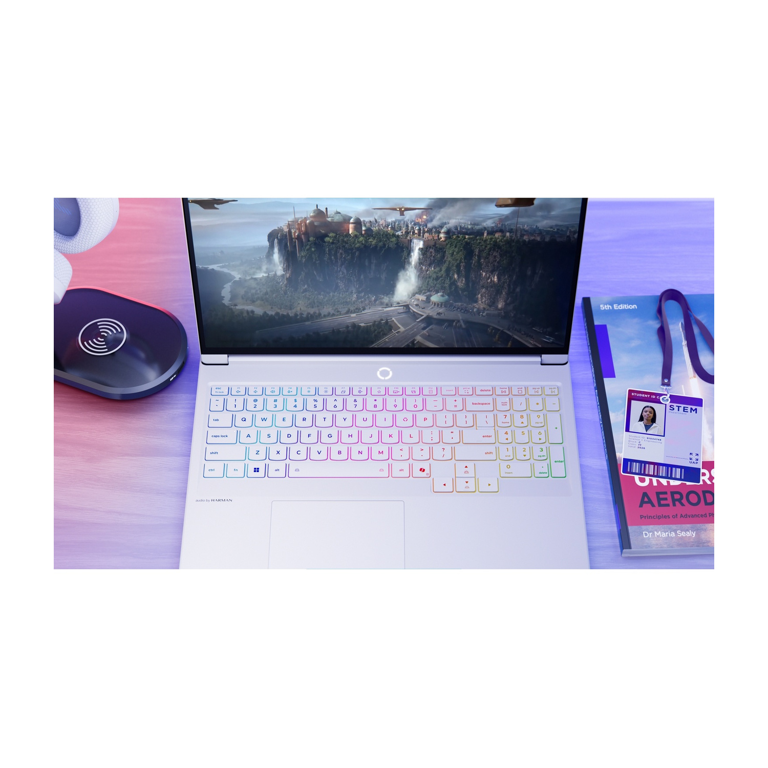 Un laptop che mostra una scena di città fantasy, accanto a un libro.