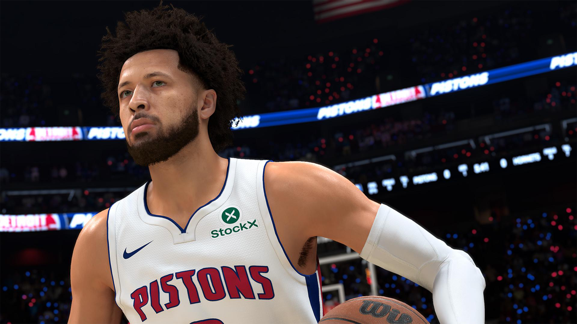 Ein Basketballspieler im weißen Pistons-Trikot mit dunklem lockigem Haar blickt zur Seite.