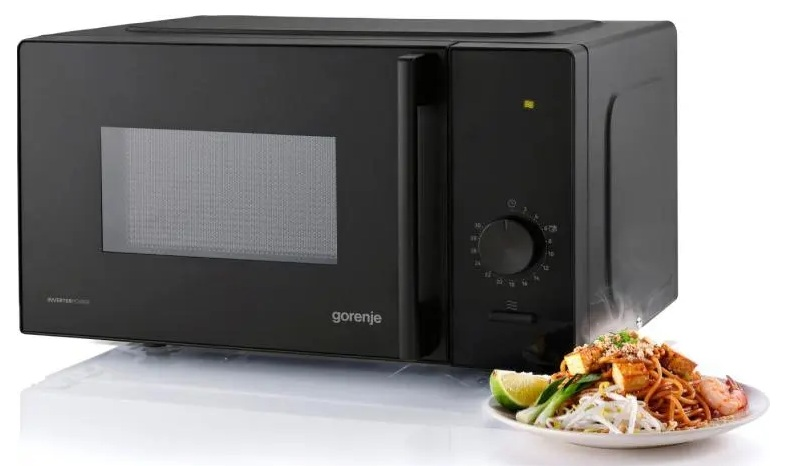 Czarna kuchenka mikrofalowa Gorenje z talerzem Pad Thai przed nią.