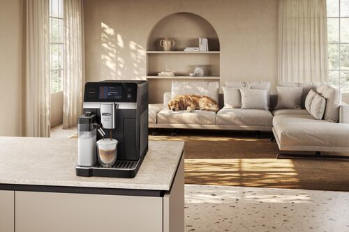 Machine à café prépare du café dans un verre, chien sur canapé.