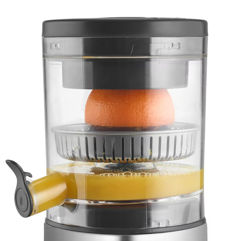 Eine Zitruspresse mit einer Orange und frisch gepresstem Saft.