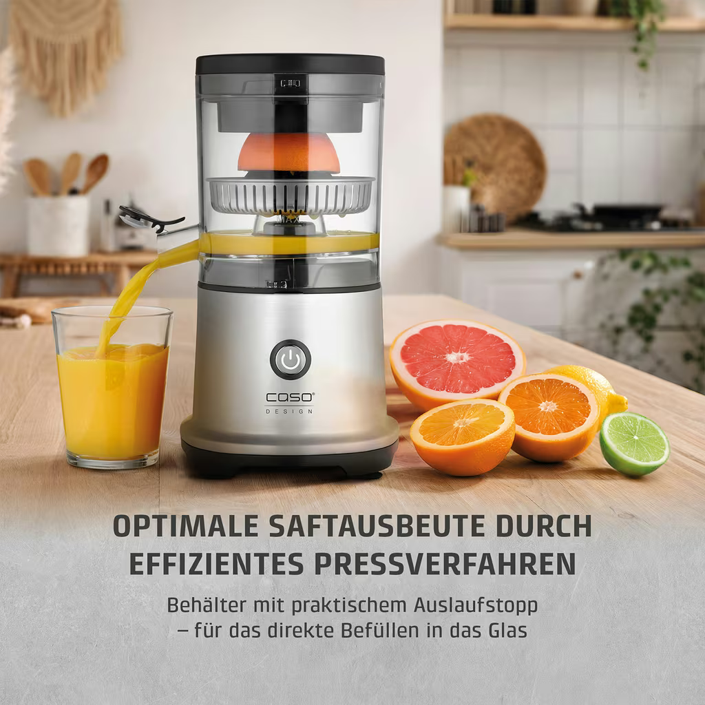 Ein Entsafter presst eine Orange, während Saft in ein Glas fließt. Früchte liegen daneben.