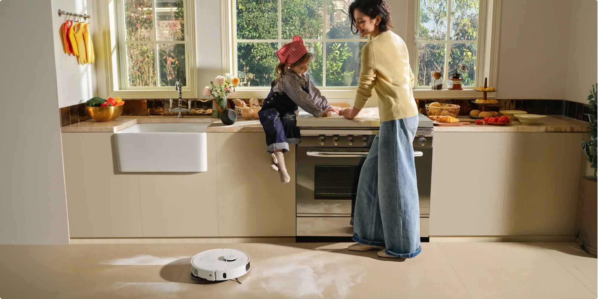 Anya és lánya süt a konyhában, porszívó robot takarít.