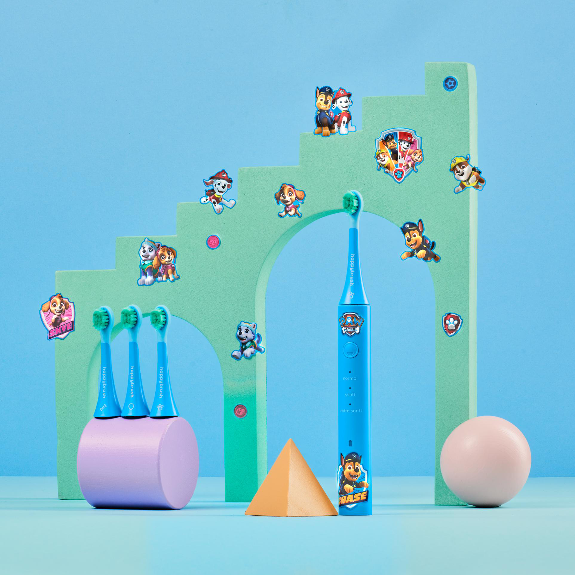 Paw Patrol Zahnbürsten mit Treppen und Spielzeug auf blauem Hintergrund.