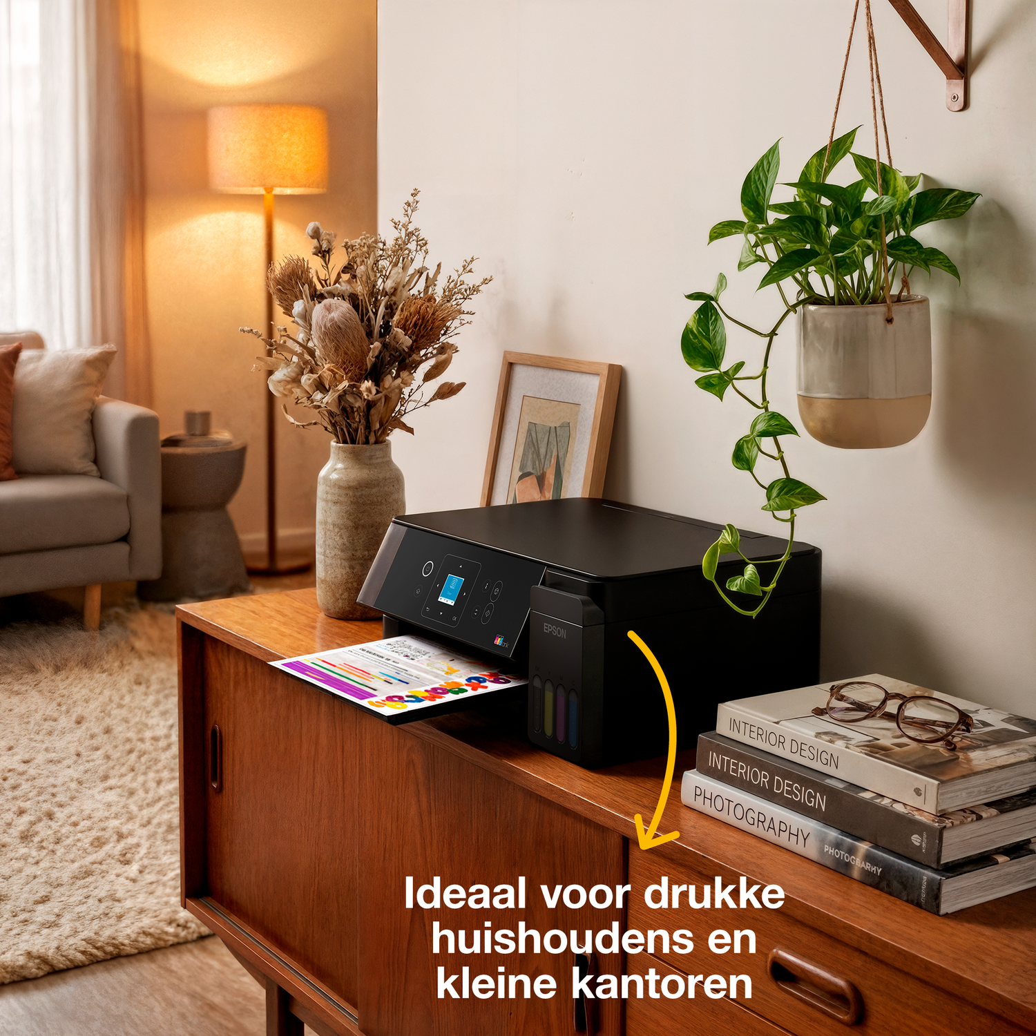 Een zwarte printer op een houten kast met boeken, een plant en een kleed ernaast.