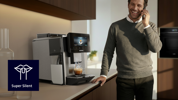 Telefonla konuşan adam, Siemens kahve makinesinden espresso yapıyor. Super Silent logosu.