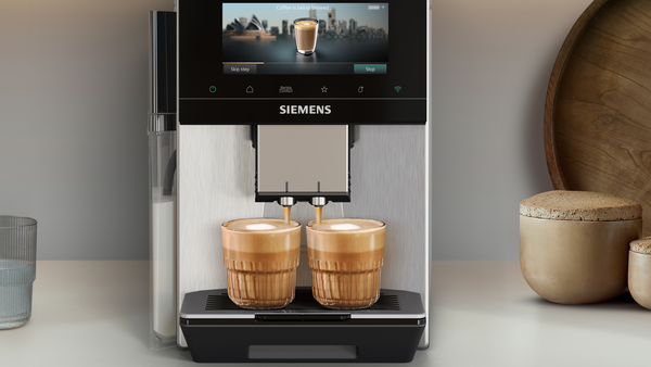 Siemens kahve makinesi bardaklara iki kapuçino yapıyor. Ekranda Sydney gösteriliyor.