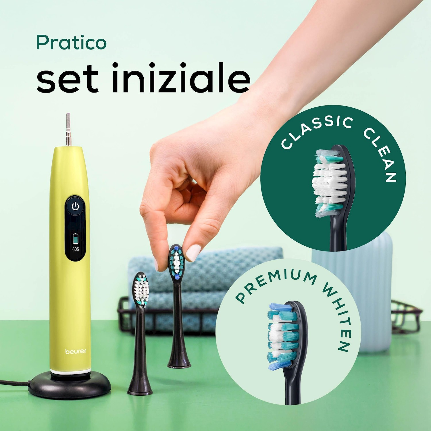 Un set di spazzolino elettrico giallo con testine e una mano.