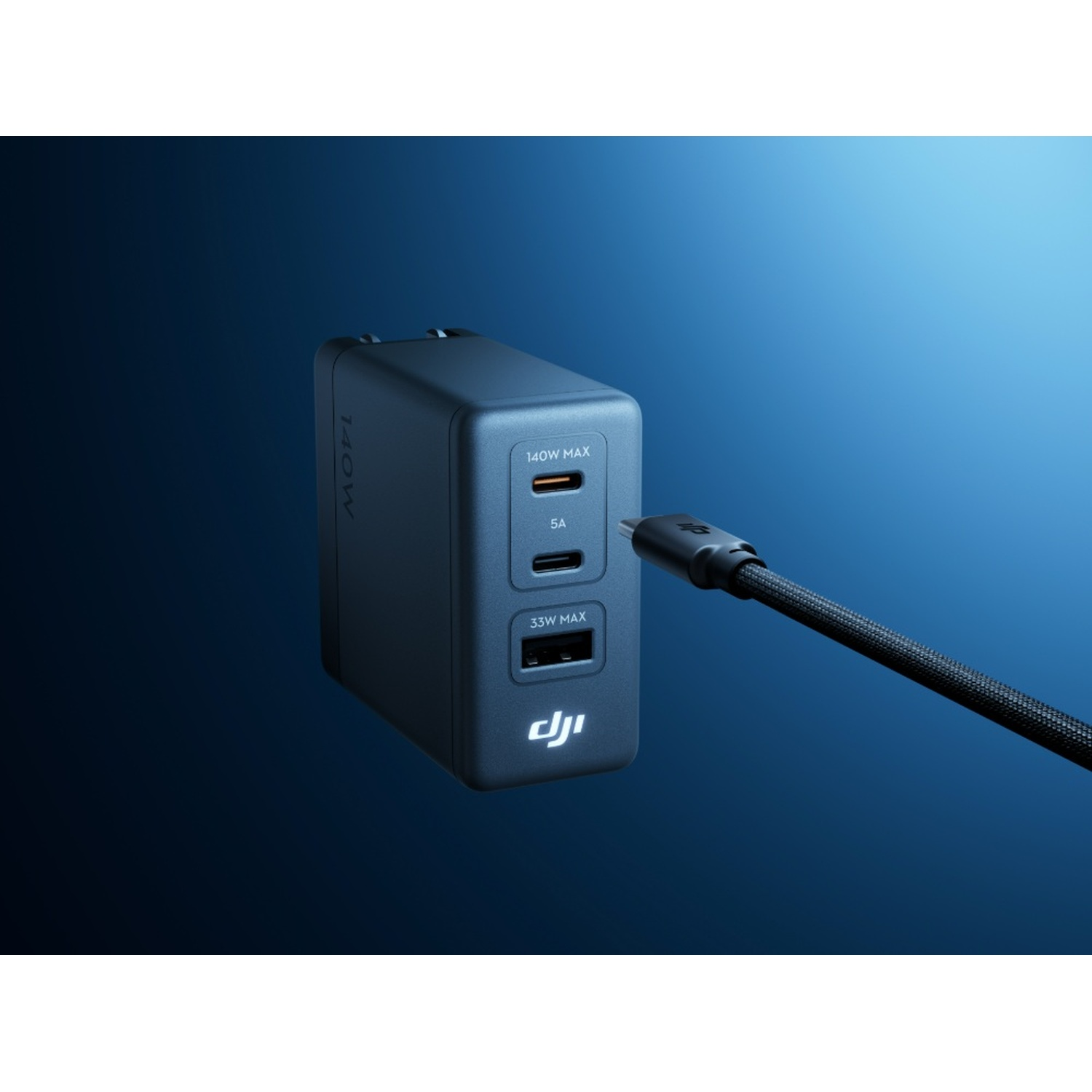 Caricabatterie USB-C DJI blu con tre porte e un cavo nero collegato su sfondo blu.
