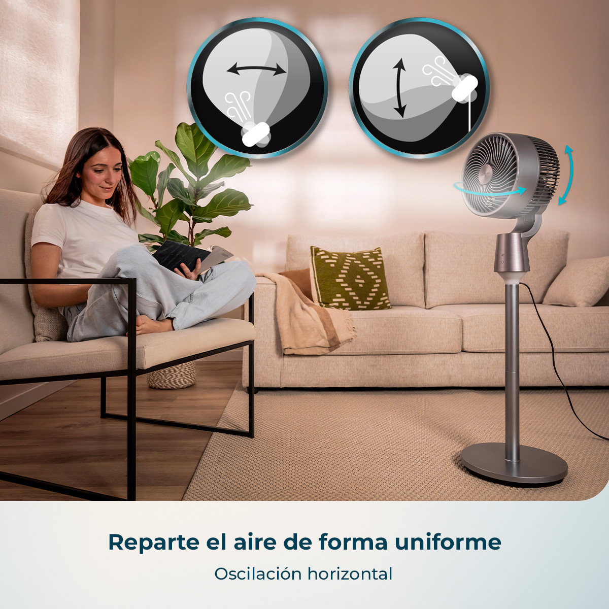 Una mujer está sentada en una silla leyendo un libro al lado de un ventilador de pie oscilante.